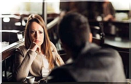 woman facing a man in a cafe