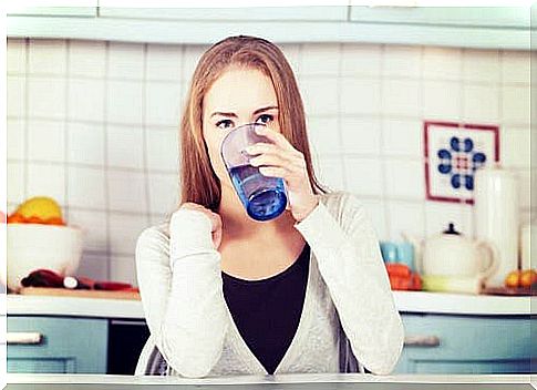 A woman drinking a glass of water. 